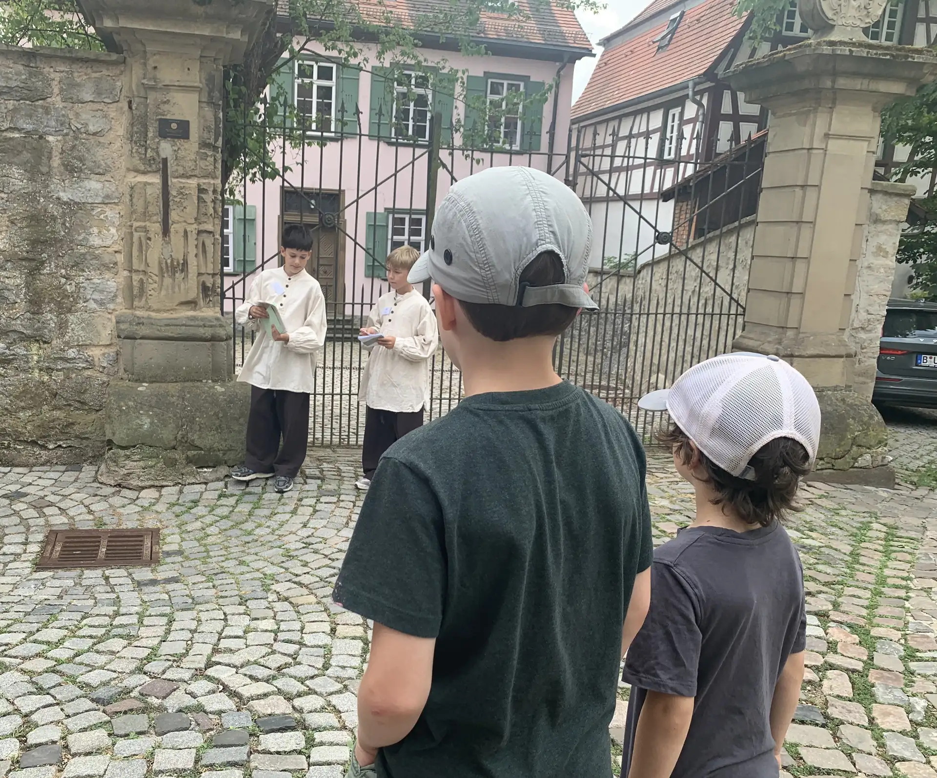 Kindergruppe vor einem Torbogen in Bad Wimpfen, einige Kinder zeigen auf das Umfeld und stehen gemeinsam für ein Foto.