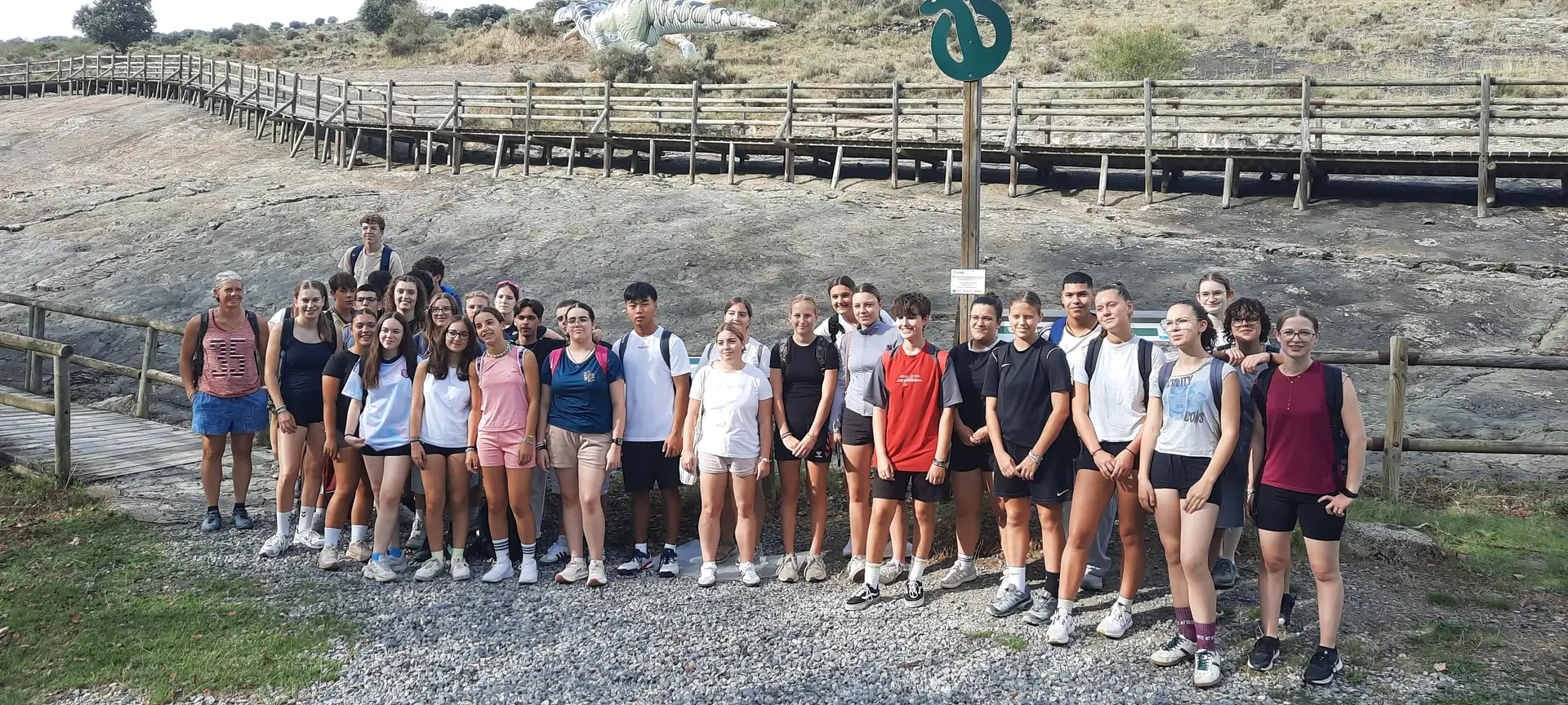 Gruppenfoto von mehreren Jugendlichen, die gemeinsam für ein Bild posieren und ein Transparent halten.