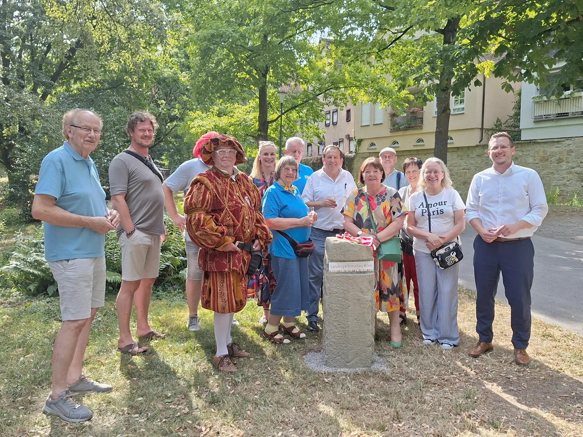 Oberbürgermeister Patrick Wegener und Gäste am neuen Gedenkstein der Landesgartenschau-Allee im Öhringer Hofgarten
