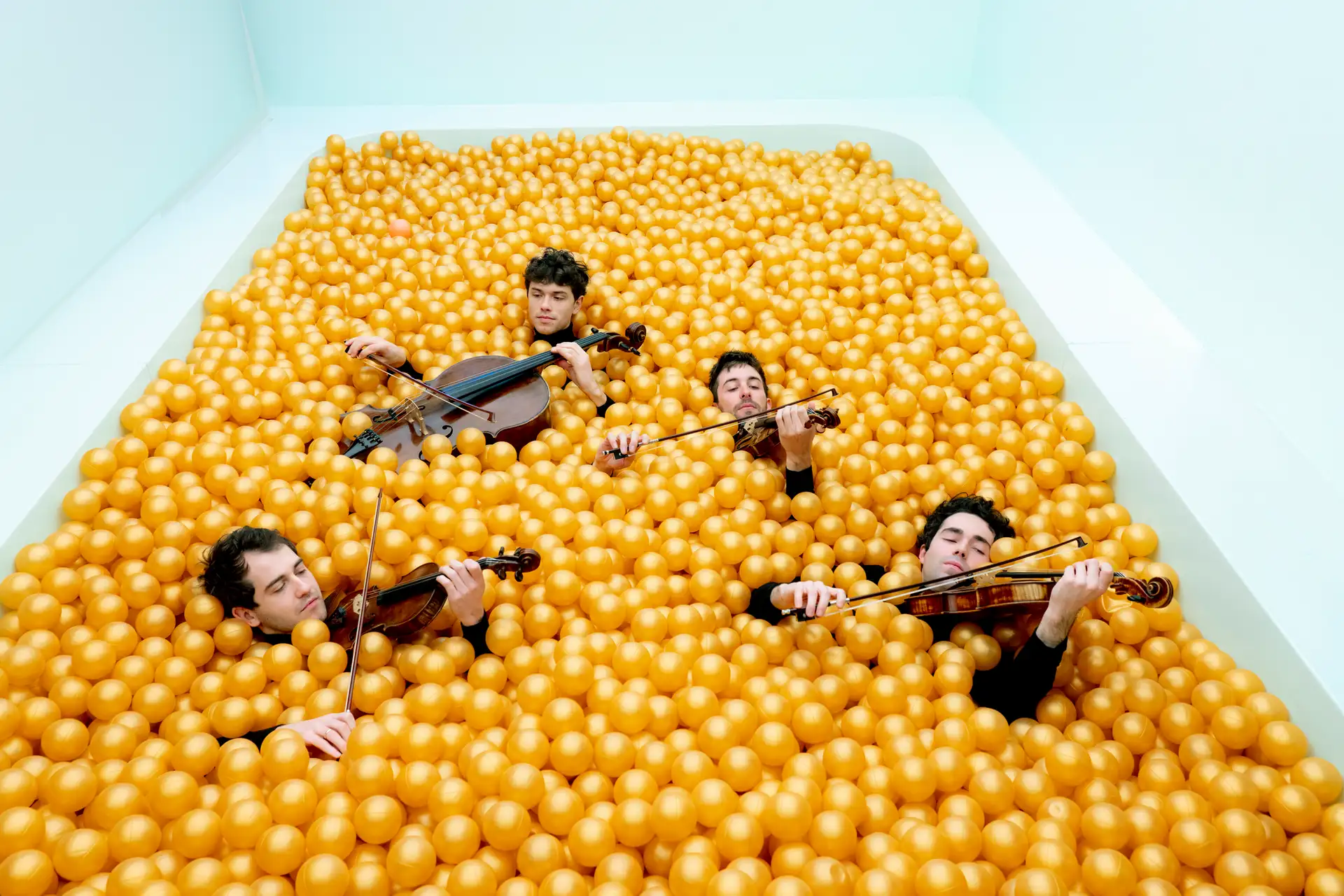 Streichquartett auf einer Bühne mit mehreren Musikern und ihren Streichinstrumenten.