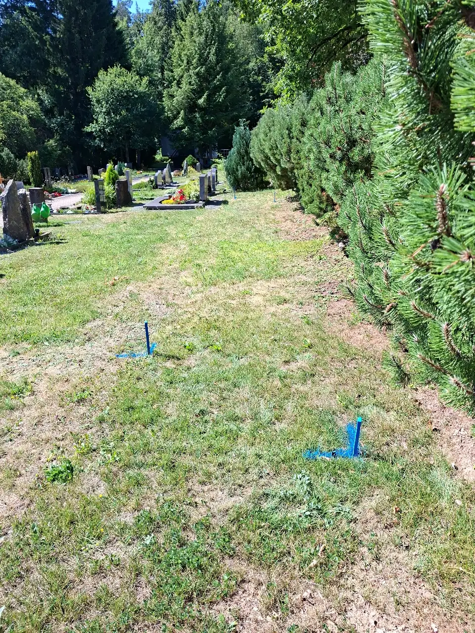 Pflasterrampe mit Geländersicherung am Zugang zu einem Friedhof