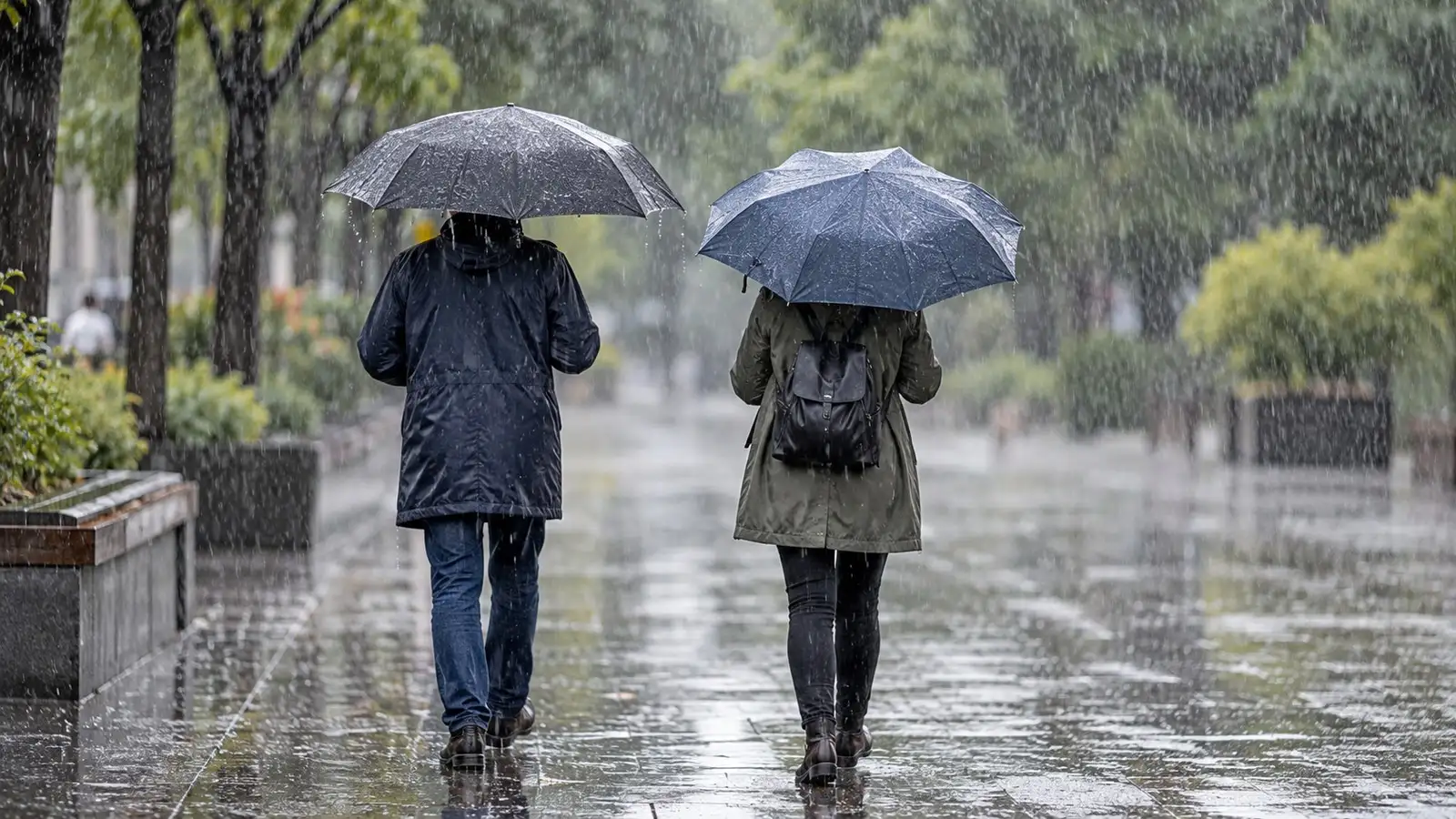 Regenschirme bei starkem Regen. Neutrale Alltagskulisse ohne behaupteten Aufnahmeort.