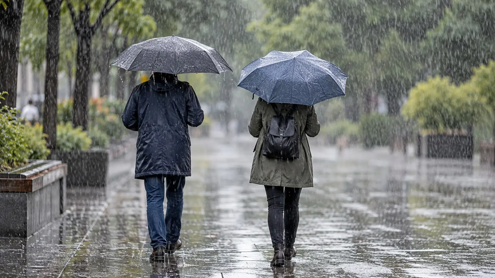 Regenschirme bei starkem Regen. Neutrale Alltagskulisse ohne behaupteten Aufnahmeort.