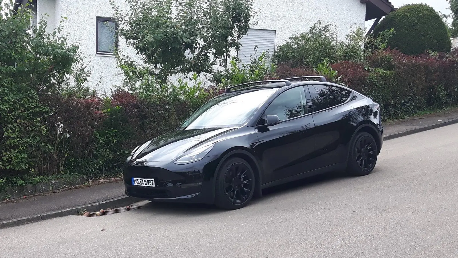 Ein schwarzer Tesla Model Y auf einer Straße.